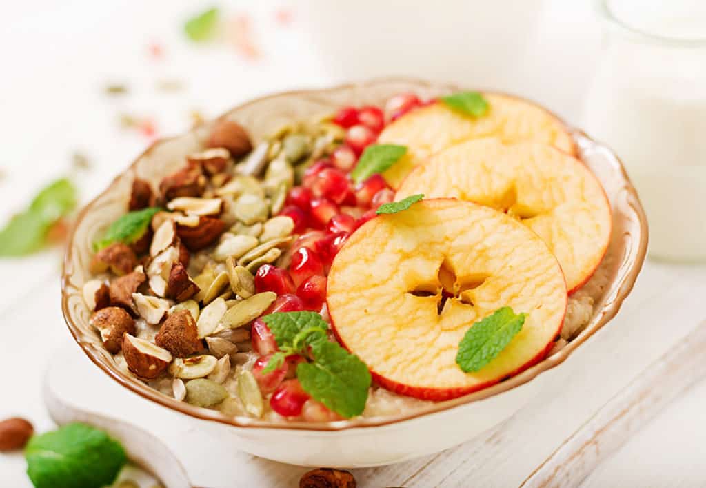 Tasty and healthy oatmeal porridge with apples, pomegranate and