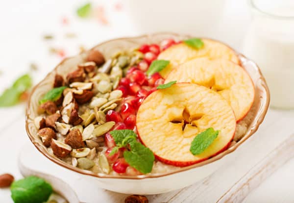 Tasty and healthy oatmeal porridge with apples, pomegranate and