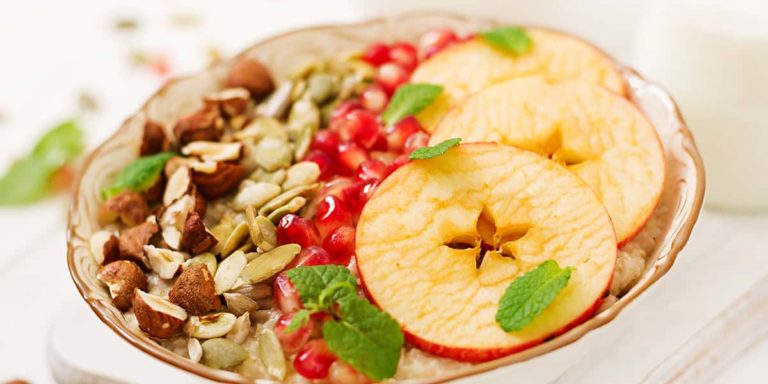 Tasty and healthy oatmeal porridge with apples, pomegranate and