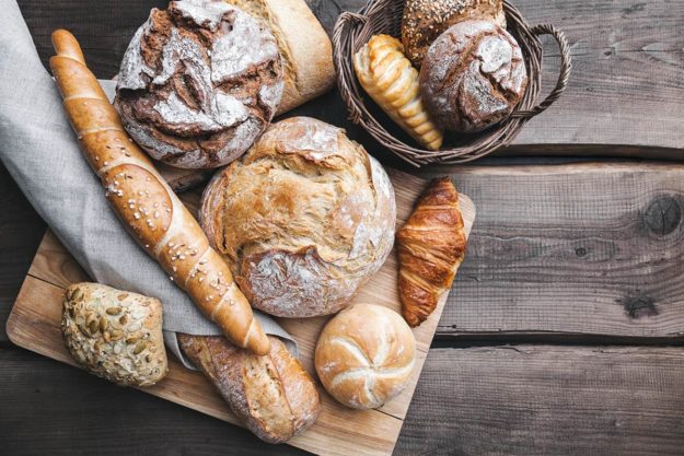 Delicious fresh bread on wooden background