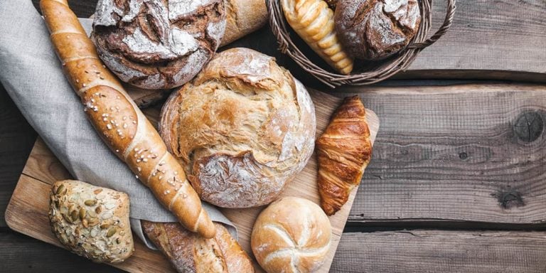 Delicious fresh bread on wooden background