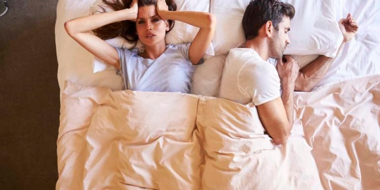 Overhead View Of Couple With Relationship Problems Lying In Bed