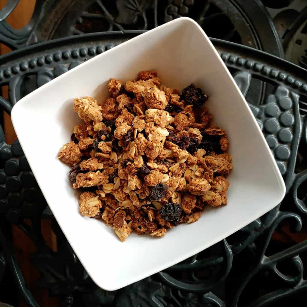 Top view of cashew butter granola in a white bowl on a grey background