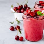 Cherry smoothie in glass with mint leaves and fresh berries