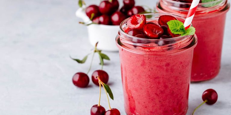 Cherry smoothie in glass with mint leaves and fresh berries