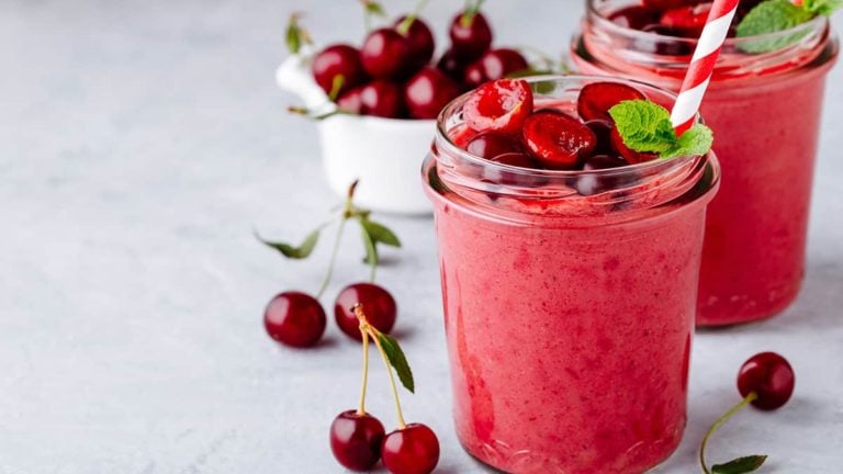 Cherry smoothie in glass with mint leaves and fresh berries