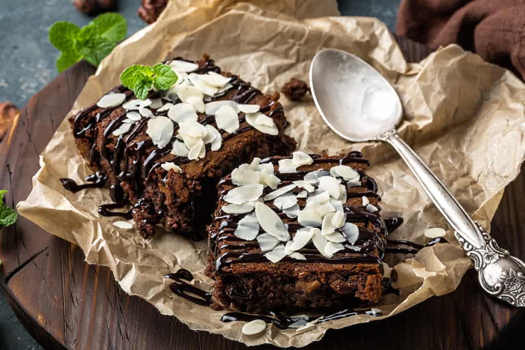 Chocolate brownie cake, dessert with nuts on dark background, directly above, flat lay