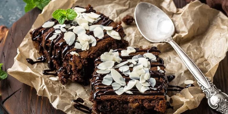 Chocolate brownie cake, dessert with nuts on dark background, directly above, flat lay