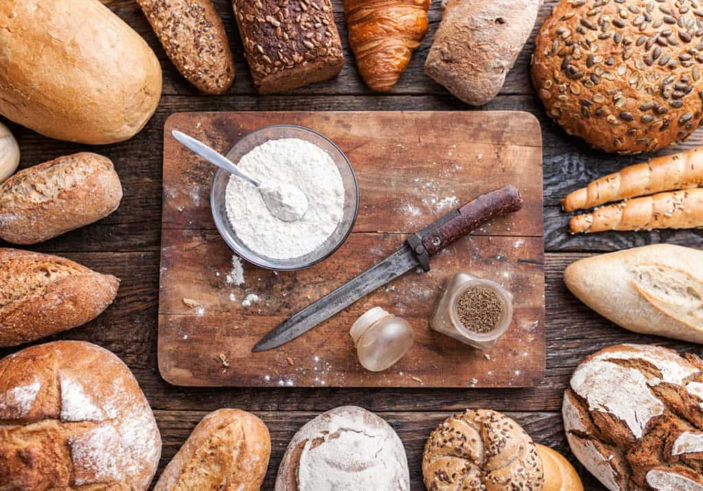 Delicious fresh bread on wooden background