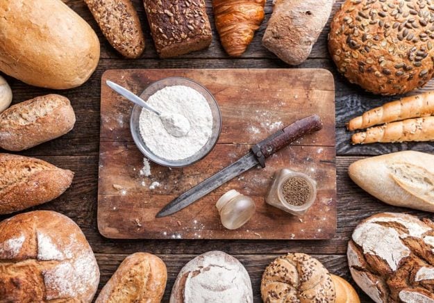 Delicious fresh bread on wooden background