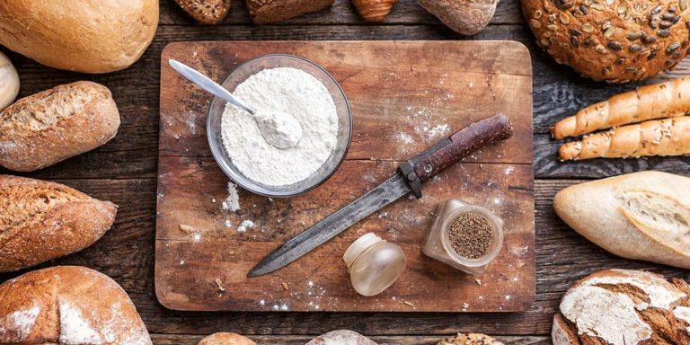 Delicious fresh bread on wooden background