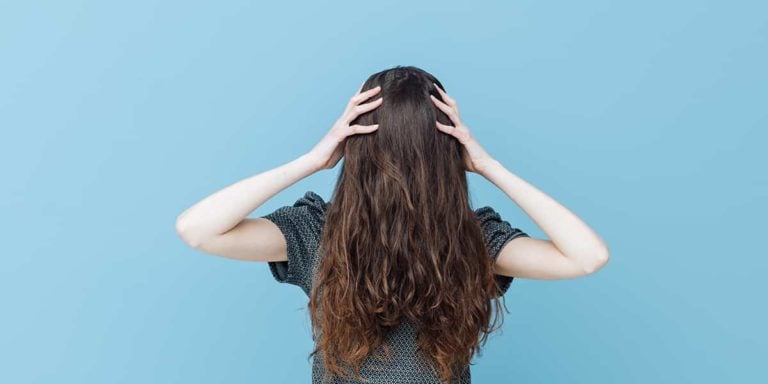 Woman with face covered behind her hair