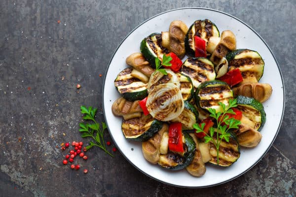 Salad with grilled vegetables and mushrooms. Vegetable salad with grilled champignons. Grilled salad on plate