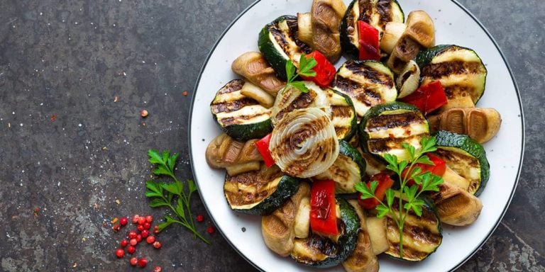 Salad with grilled vegetables and mushrooms. Vegetable salad with grilled champignons. Grilled salad on plate