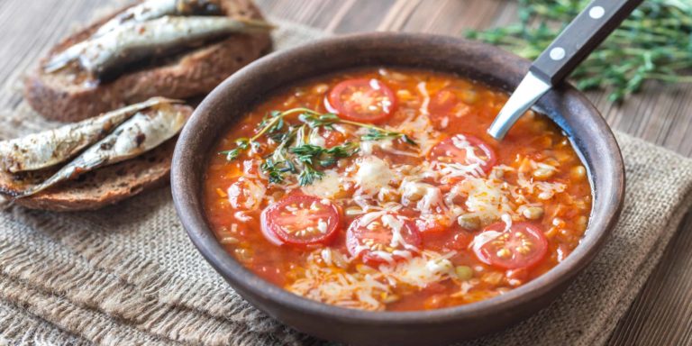 Portion of green lentil tomato soup with toasts