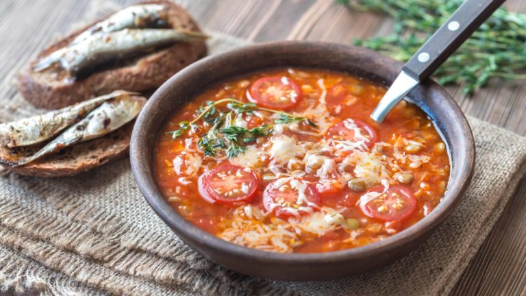 Portion of green lentil tomato soup with toasts