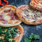 Mini pizzas with various toppings on the wooden board