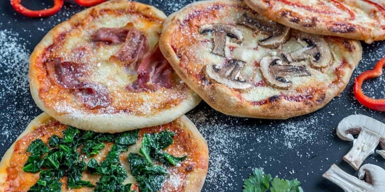 Mini pizzas with various toppings on the wooden board