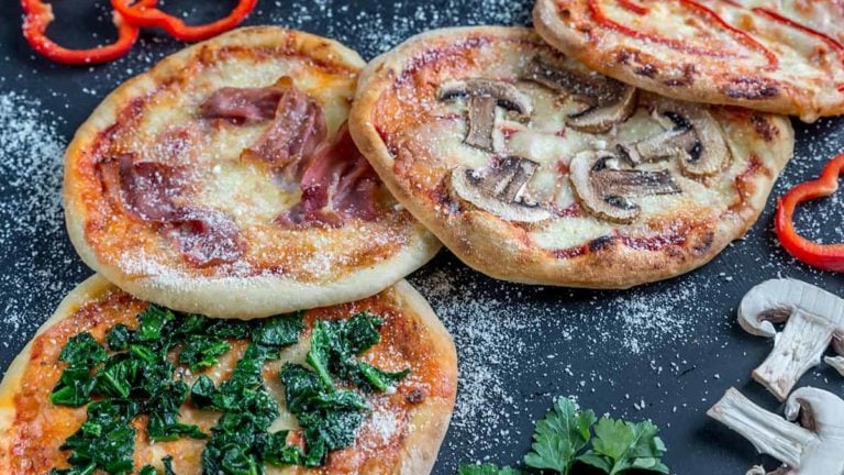 Mini pizzas with various toppings on the wooden board