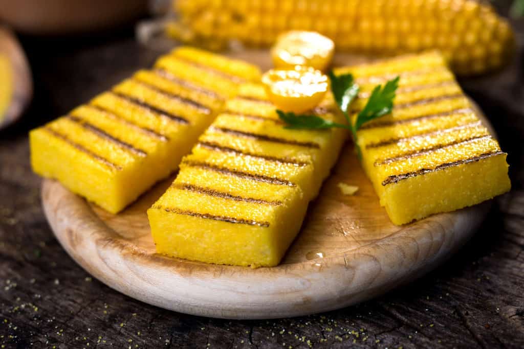 Grilled polenta on old wooden background