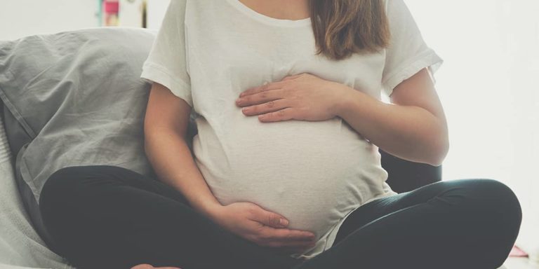 Pregnant woman touching her belly
