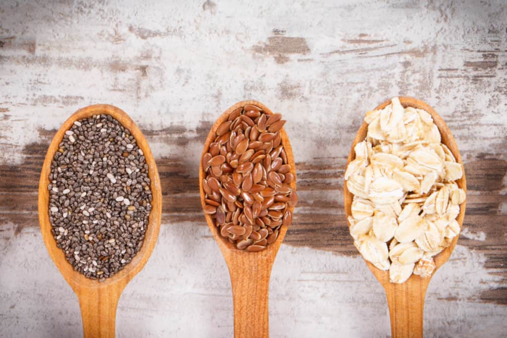 spoons with chia seeds, flax seeds, and oats