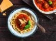 Pasta with meatballs and spicy marinara sauce and cheese, top view, rustic style.