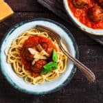 Pasta with meatballs and spicy marinara sauce and cheese, top view, rustic style.