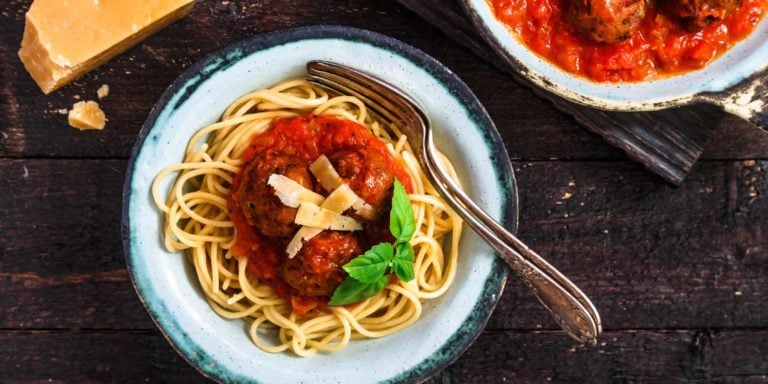 Pasta with meatballs and spicy marinara sauce and cheese, top view, rustic style.