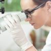 Woman using microscope in laboratory