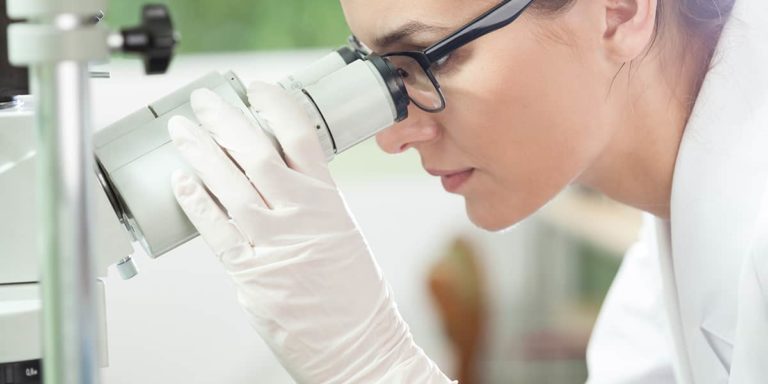Woman using microscope in laboratory